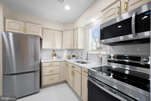 a kitchen with a refrigerator sink and white cabinets