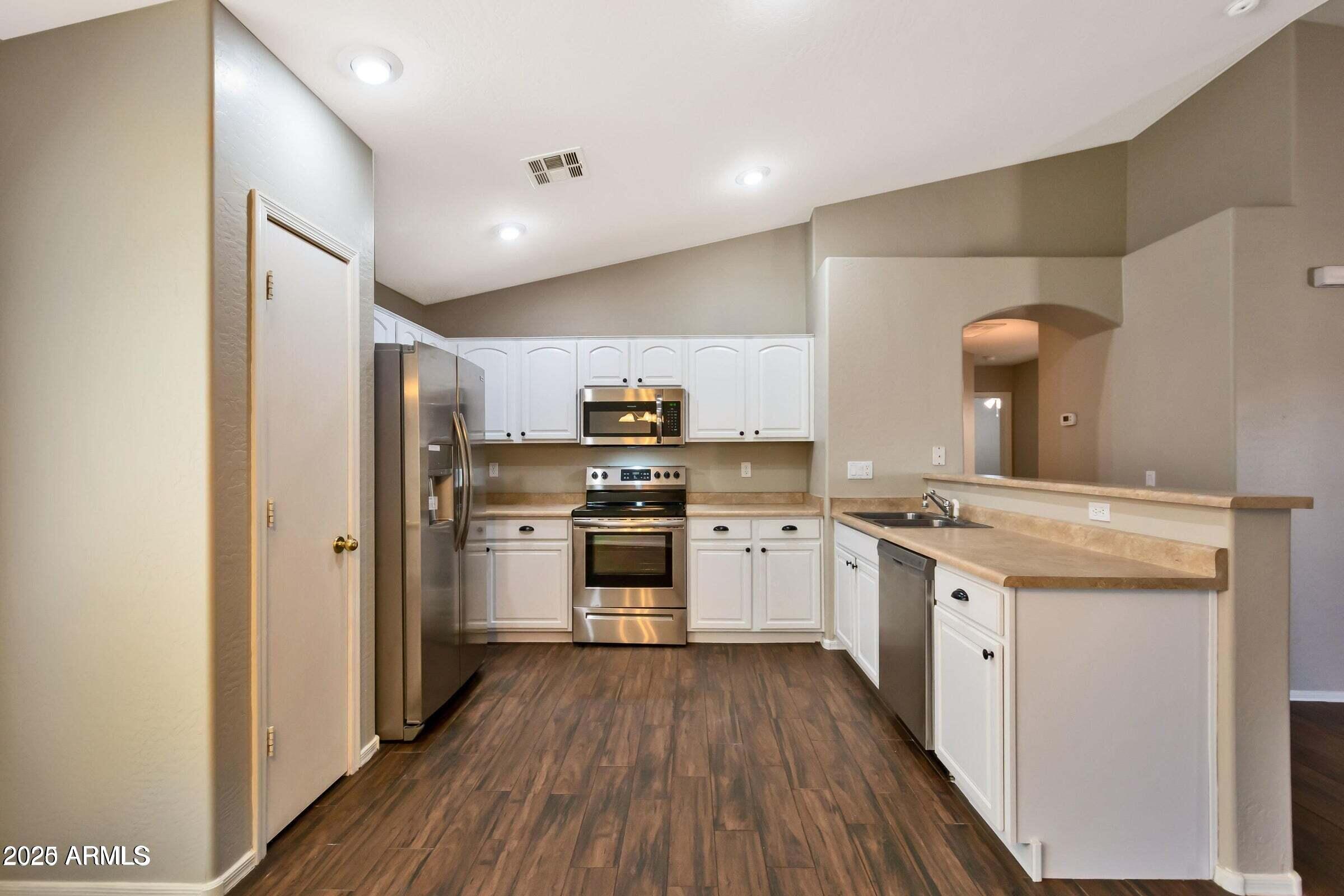 1228 East Elm Road San Tan Valley, AZ 85140 - Photo 2 of 13 a kitchen with a white cabinets and wooden floor