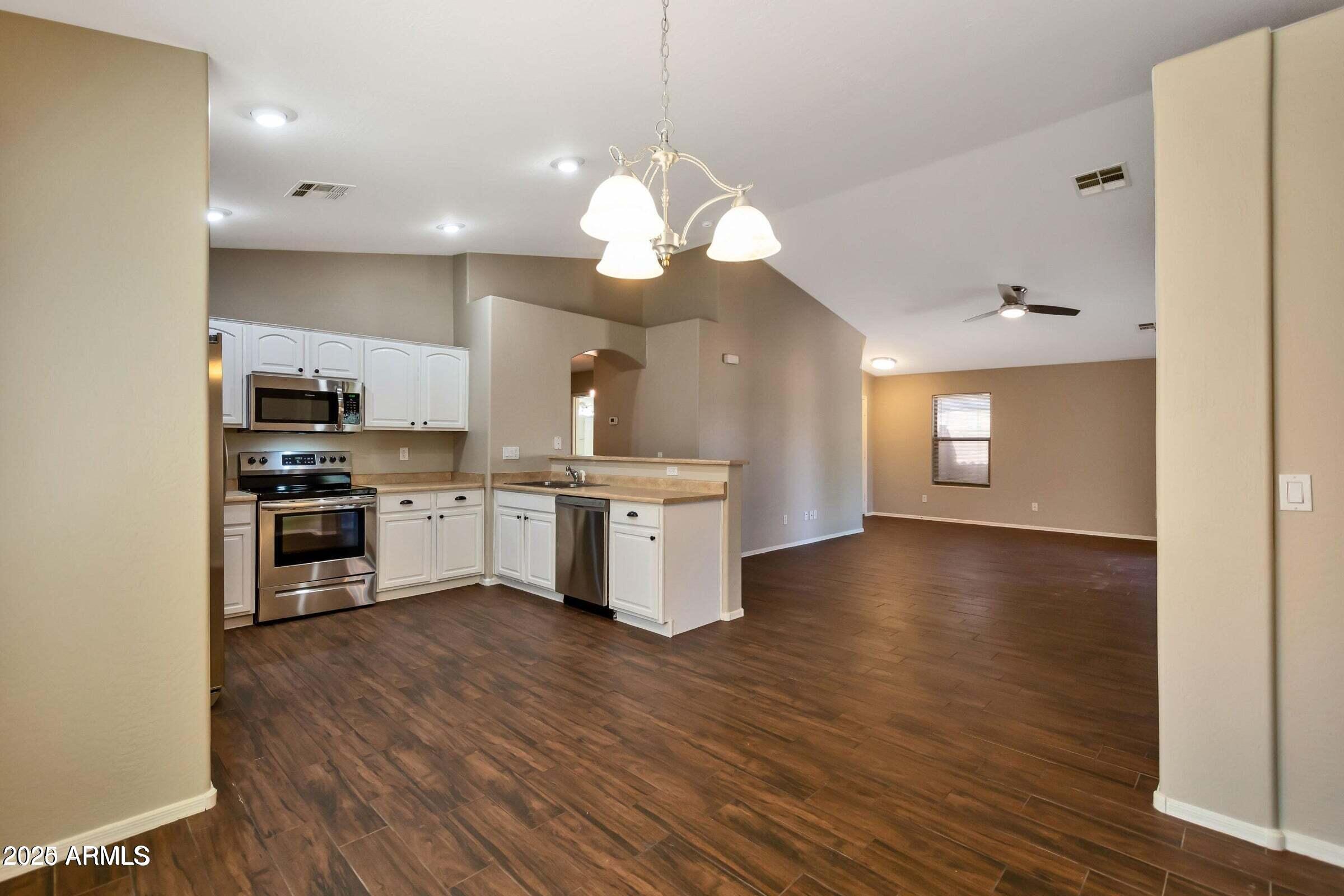 1228 East Elm Road San Tan Valley, AZ 85140 - Photo 3 of 13 a kitchen with a sink and a stove top oven