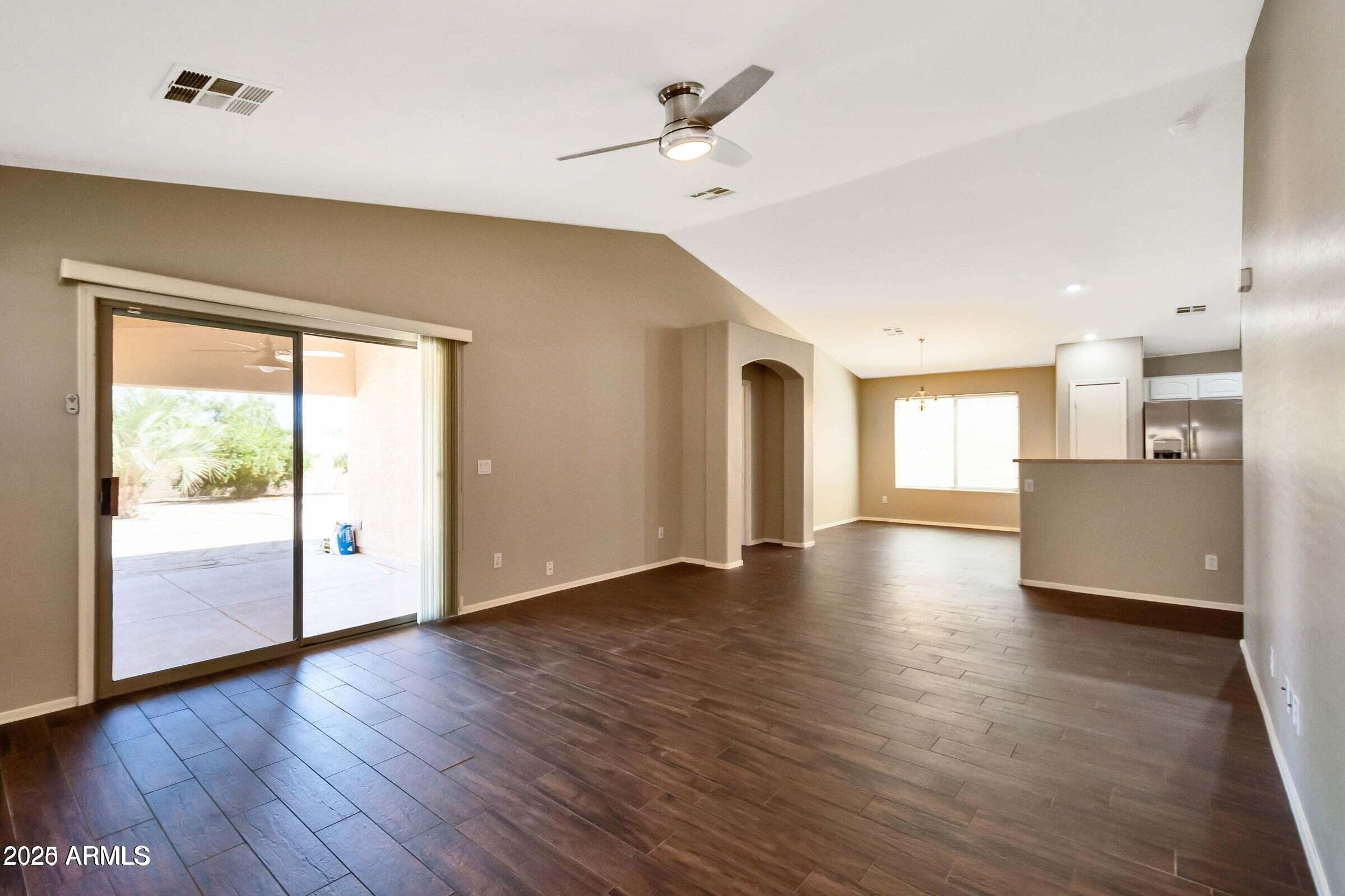 1228 East Elm Road San Tan Valley, AZ 85140 - Photo 4 of 13 a view of an empty room with wooden floor and a window