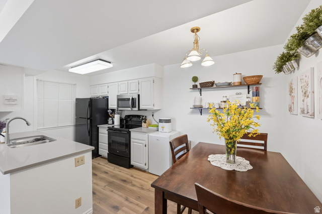 650 South Main Street, Unit 3304 Bountiful, UT 84010 - Photo 7 of 22 Kitchen and dining area featuring wood-finish flooring, white cabinetry, and black appliances