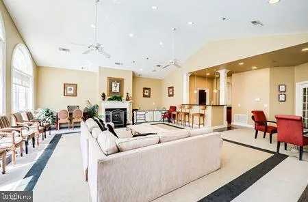 a living room with furniture kitchen view and a wooden floor