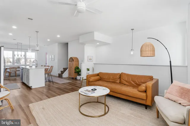 a living room with furniture a rug and kitchen view