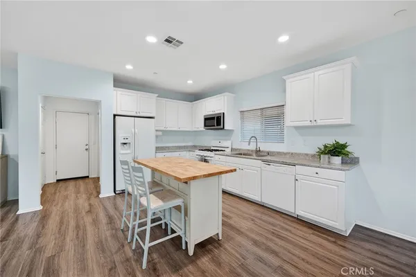 a bed sitting in a bedroom next to a window with wooden floor