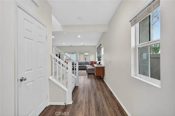 a kitchen with stainless steel appliances kitchen island granite countertop a dining table chairs and white cabinets