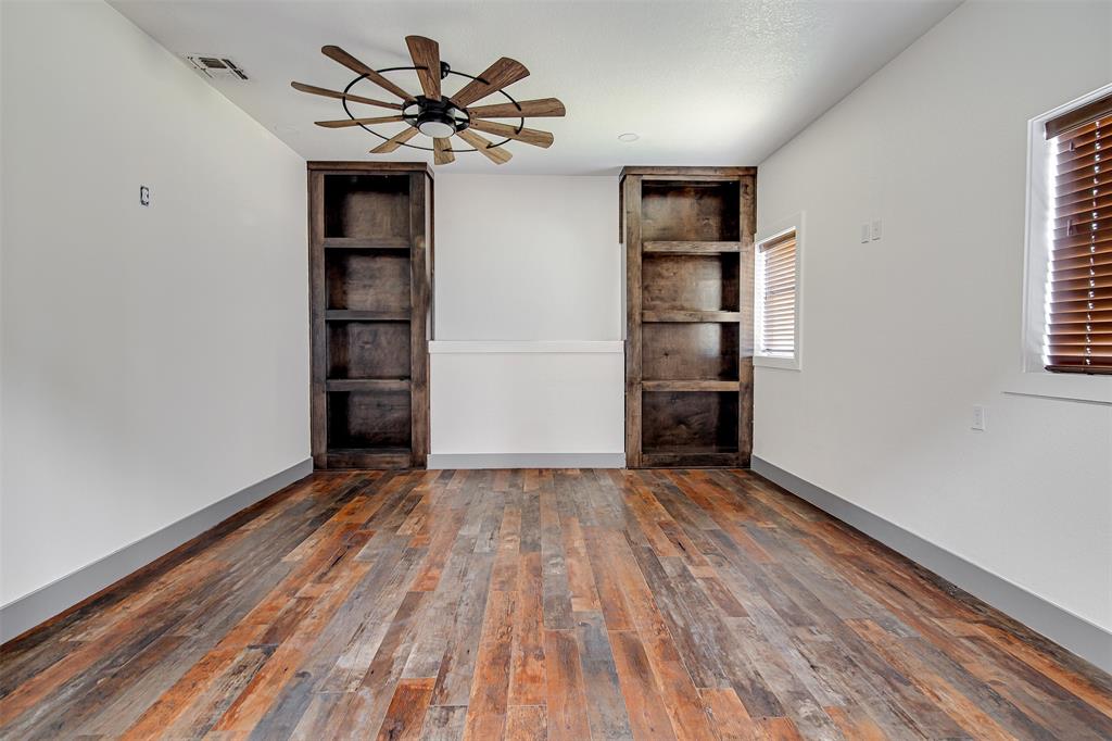 801 South Hampton Road Crowley, TX 76036 - Photo 11 of 26 Spare room featuring built in features, ceiling fan, and dark wood-style floors