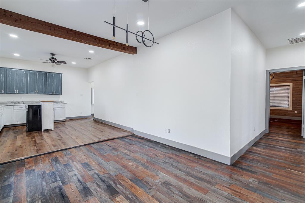 801 South Hampton Road Crowley, TX 76036 - Photo 12 of 26 Kitchen with beam ceiling, ceiling fan, dark wood-style flooring, white cabinetry, and decorative light fixtures