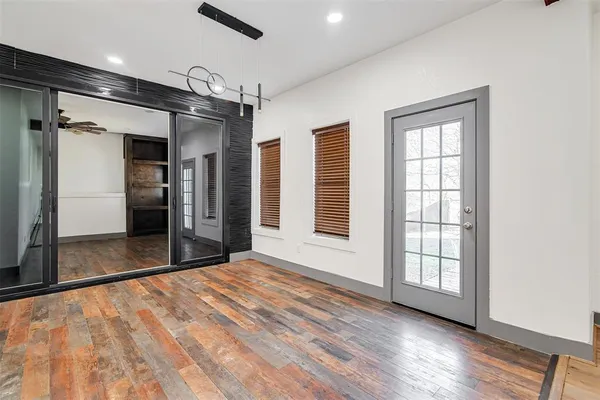 an empty room with wooden floor and a hallway