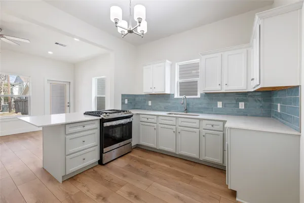 a kitchen with stainless steel appliances granite countertop a stove and white cabinets