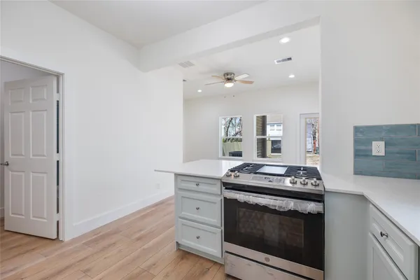 a kitchen with stainless steel appliances granite countertop a stove and a white cabinets