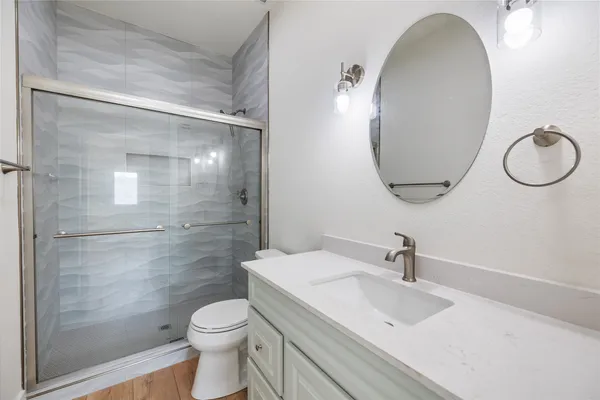 a bathroom with a sink a toilet and shower