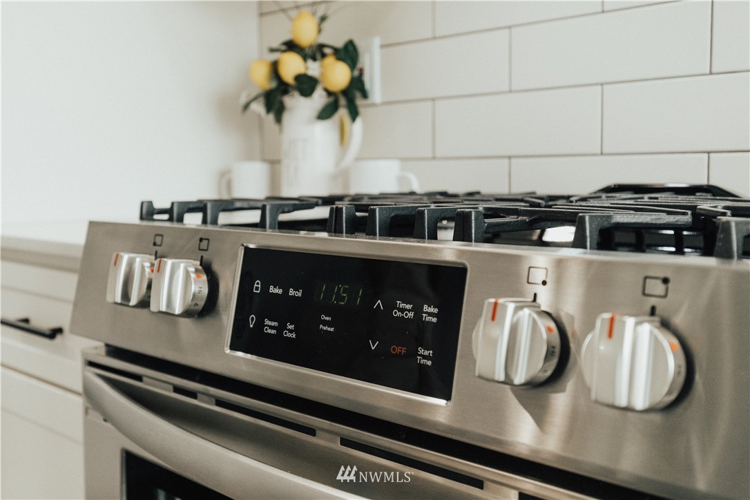 3638 36th Avenue South, Unit D Seattle, WA 98144 - Photo 19 of 30 a kitchen with a stove and a white wooden cabinets