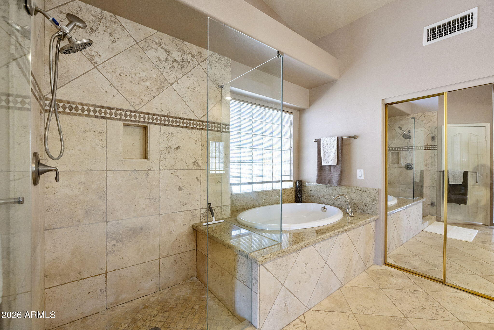 12435 West Monte Vista Road Avondale, AZ 85392 - Photo 42 of 69 a bathroom with a tub a sink a mirror and a shower