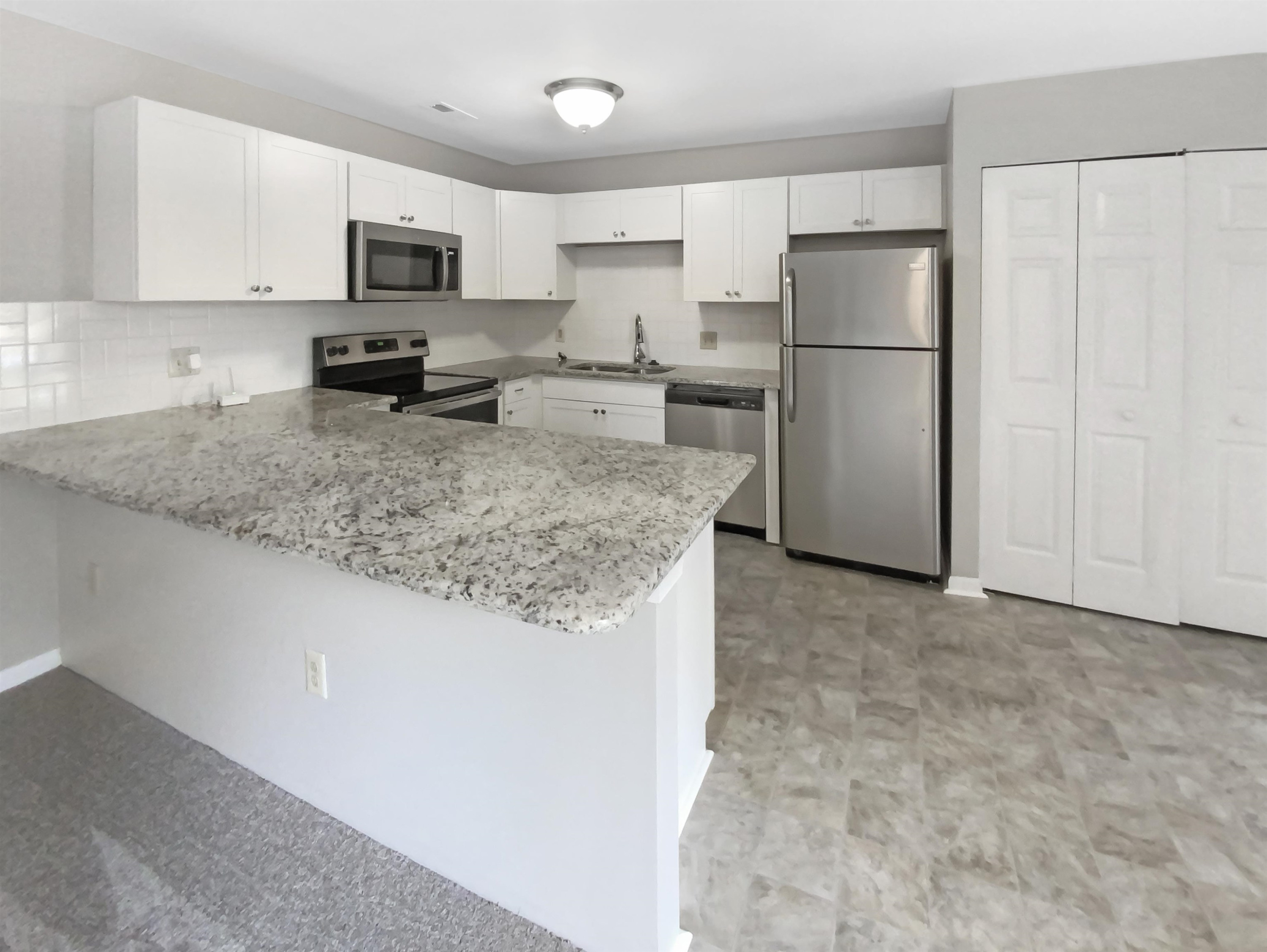 294 Summerwalk Circle Chapel Hill, NC 27517 - Photo 14 of 21 a kitchen with kitchen island a refrigerator sink stove and white cabinets