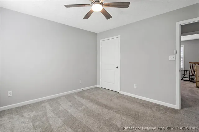 an empty room with chandelier fan