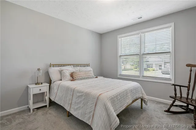 a bedroom with a bed a window and cabinet