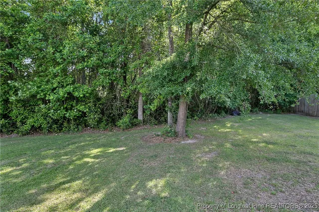 a view of a white house with a big yard and potted plants