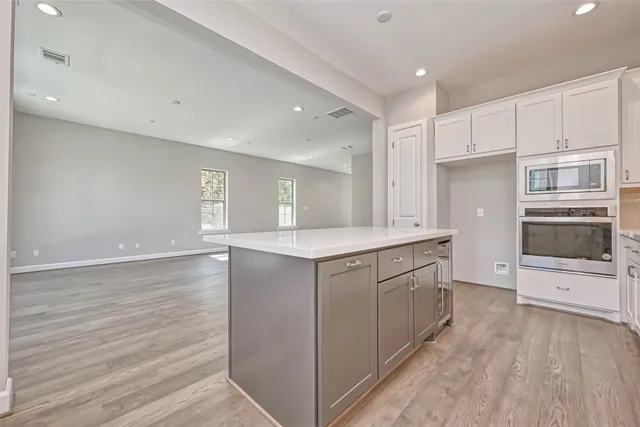 a kitchen with granite countertop white cabinets and white appliances