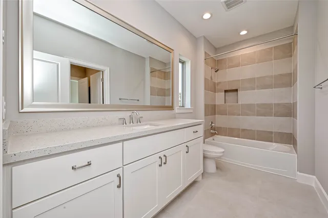 a bathroom with a double vanity sink a toilet and a bathtub