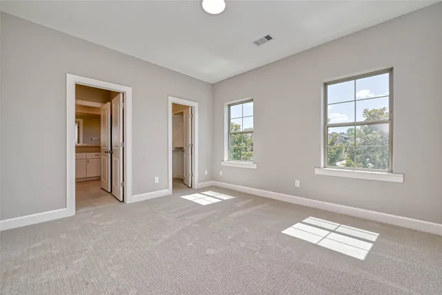 an empty room with windows and closet