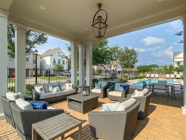 a living room with patio furniture and a floor to ceiling window