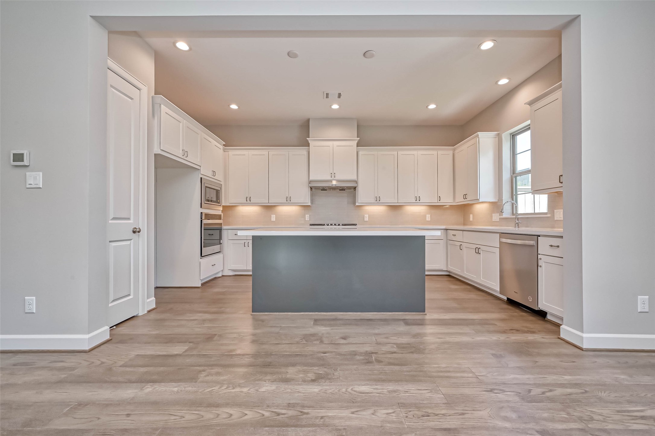 1908 Carrollton Mill Drive Spring, TX 77380 - Photo 9 of 40 a large kitchen with kitchen island white cabinets and stainless steel appliances