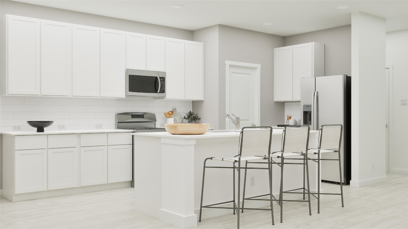 13312 Winton Drive Elgin, TX 78621 - Photo 29 of 35 a kitchen with white cabinets and stainless steel appliances