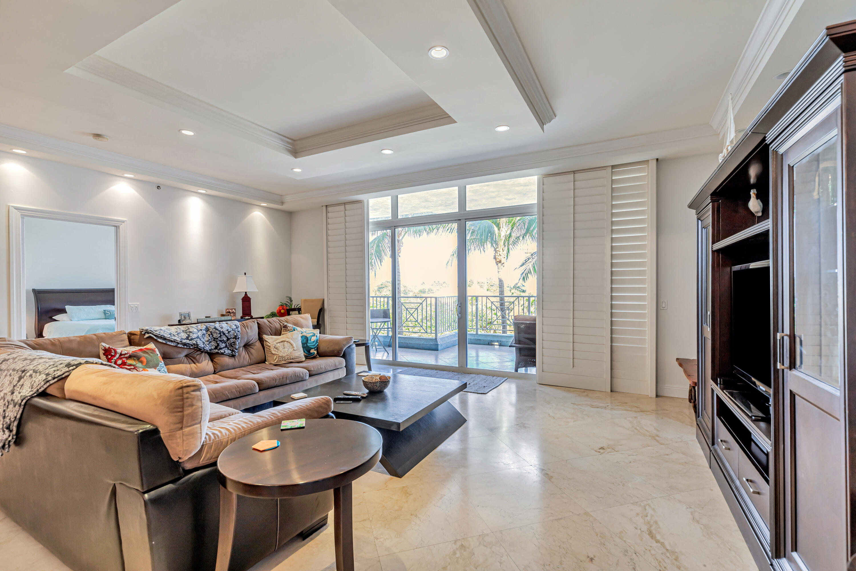 a living room with furniture a flat screen tv and a large window