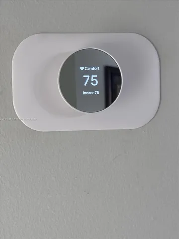 a view of a swimming pool with lawn chairs and large trees