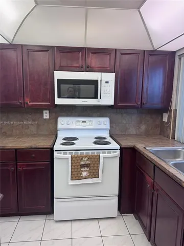 a kitchen with cabinets a sink and a stove with wooden cabinets