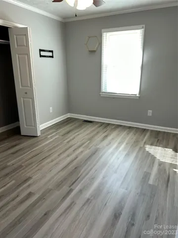 an empty room with wooden floor and a window