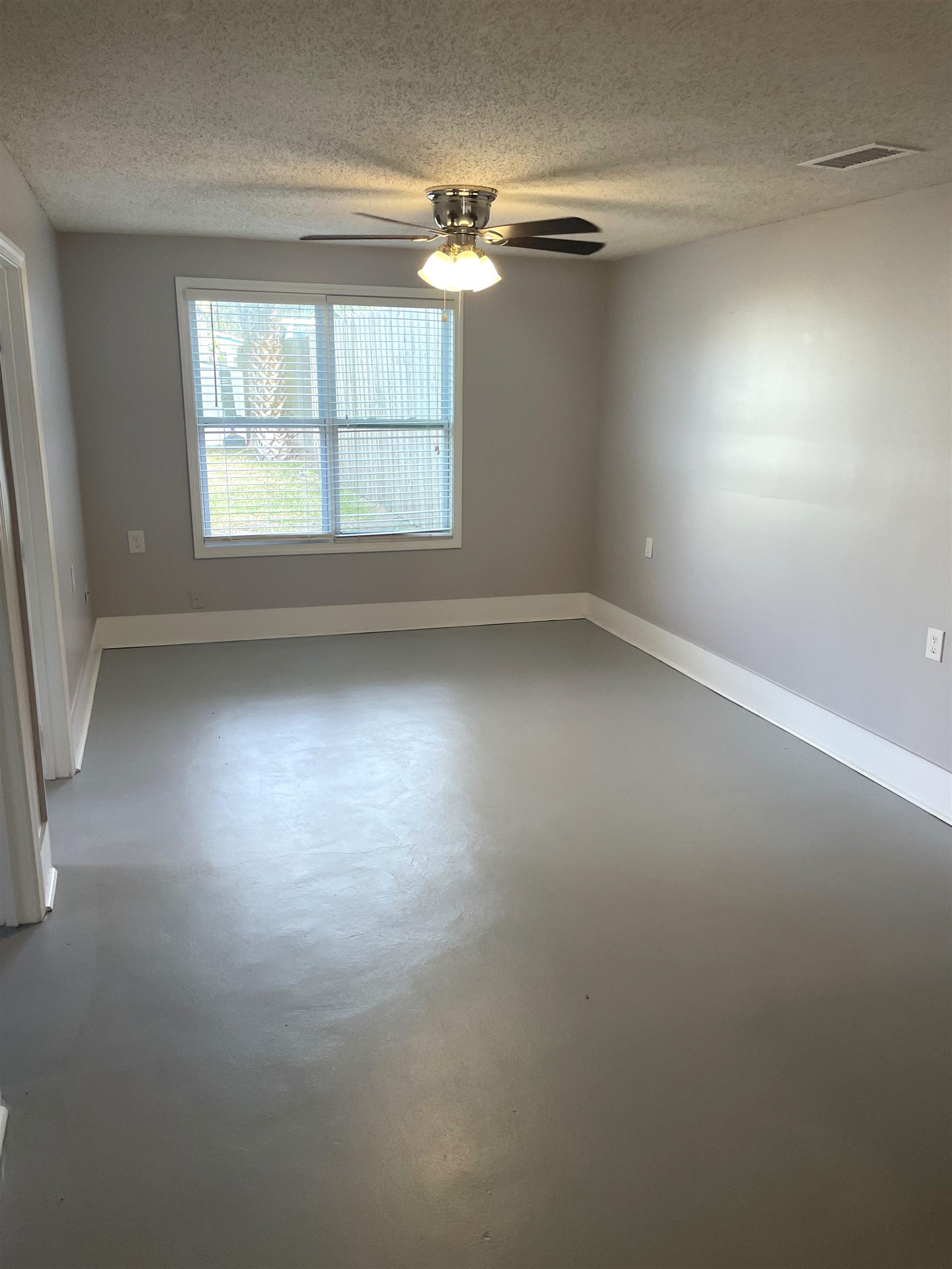 137.5 Riberia Street St. Augustine, FL 32084 - Photo 4 of 10 Spare room with a textured ceiling, finished concrete floors, and ceiling fan