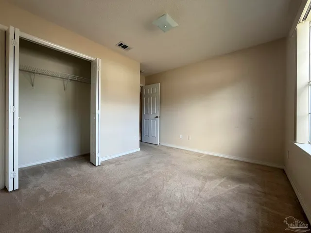 an empty room with windows and closet