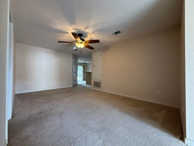 a view of an empty room and a ceiling fan