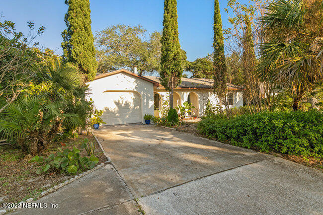 a view of a house with a yard and tree s
