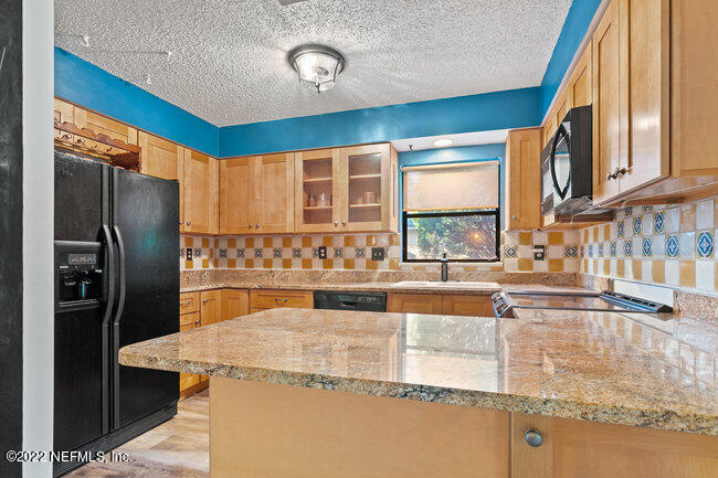 361 Shamrock Road St. Augustine, FL 32086 - Photo 11 of 30 a kitchen with stainless steel appliances granite countertop a sink and a refrigerator