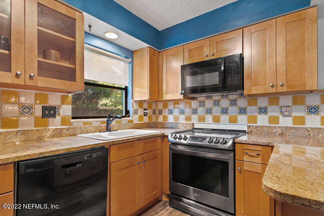 361 Shamrock Road St. Augustine, FL 32086 - Photo 13 of 30 a kitchen with stainless steel appliances granite countertop a sink stove and microwave