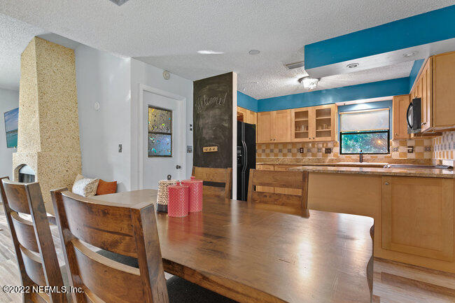 361 Shamrock Road St. Augustine, FL 32086 - Photo 8 of 30 a dining hall with stainless steel appliances kitchen island granite countertop a table and chairs