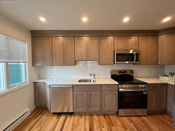 a kitchen with kitchen island granite countertop wooden cabinets and a stainless steel appliances