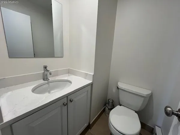 a bathroom with a granite countertop toilet sink and mirror