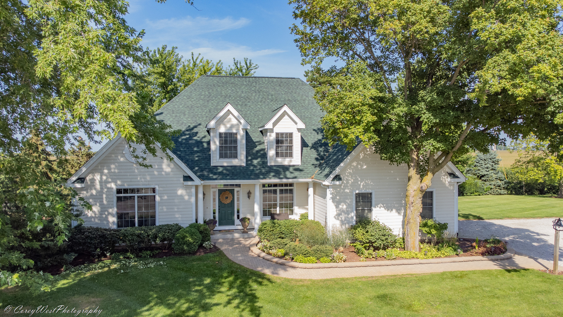a front view of a house with a yard and potted plants