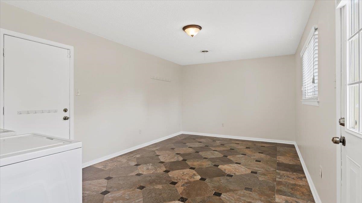 1707 Falling Leaf Road Germantown, TN 38138 - Photo 17 of 38 Empty room featuring independent washer and dryer and dark tile floors