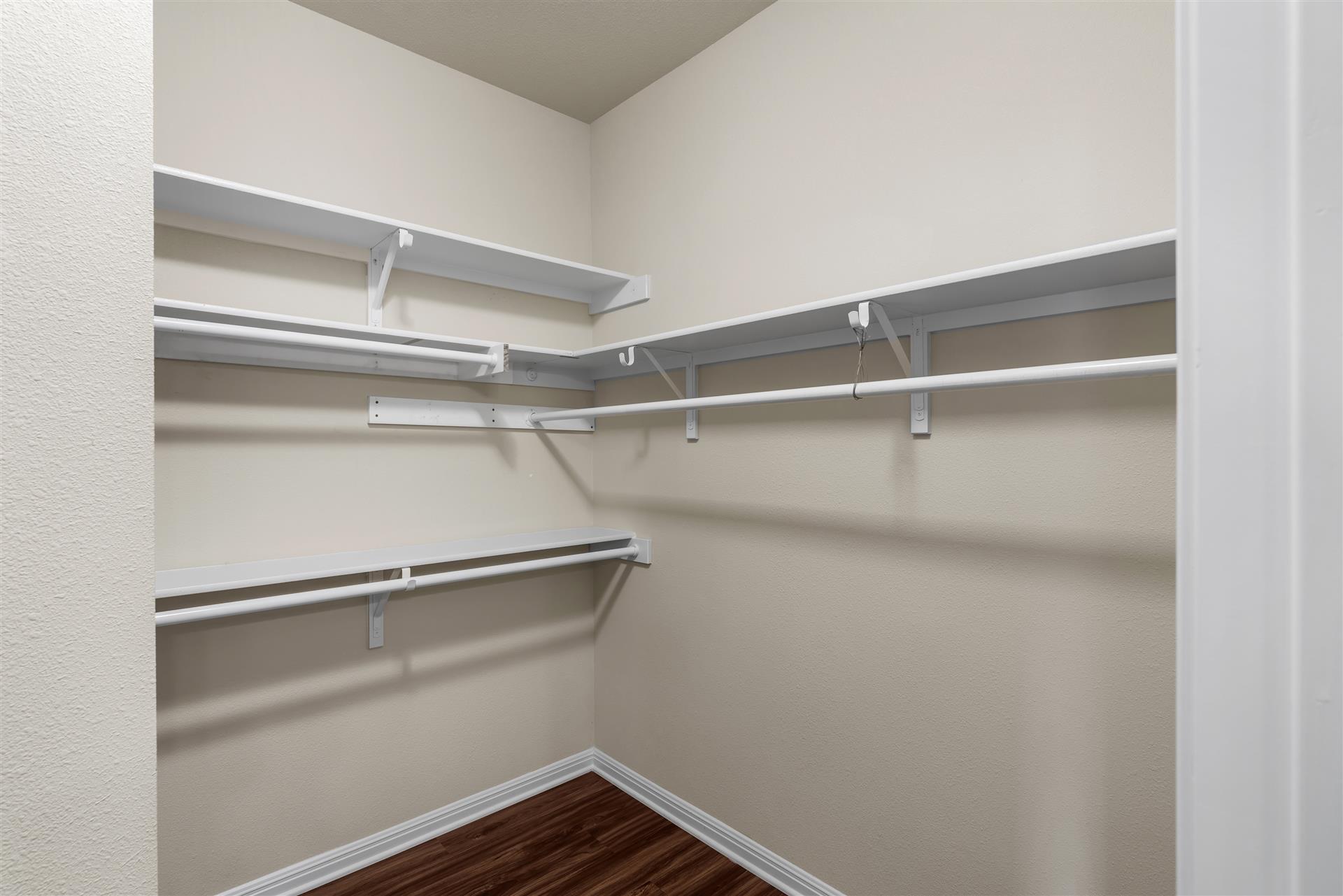 16512 Enamorado Road Manor, TX 78653 - Photo 28 of 31 Ample closet space awaits, featuring extensive shelving and hanging rods for organized storage.