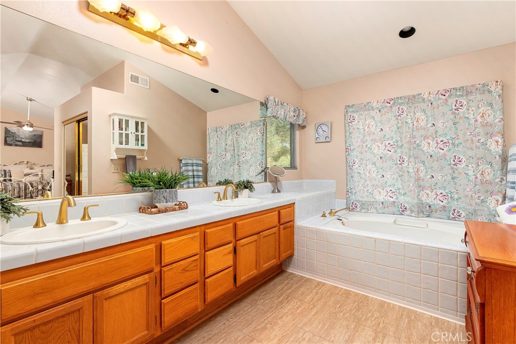 32201 Joaquin Road Acton, CA 93510 - Photo 37 of 75 a bathroom with a granite countertop tub sink double vanity granite tub shower and a mirror