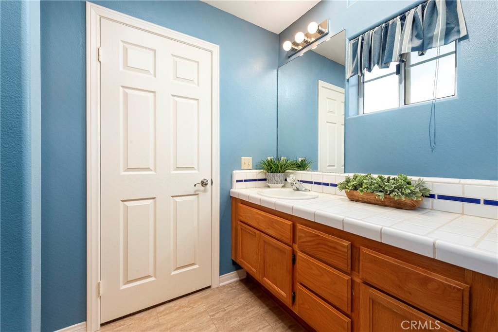 32201 Joaquin Road Acton, CA 93510 - Photo 43 of 75 a spacious en suite bathroom with a granite countertop sink and a mirror