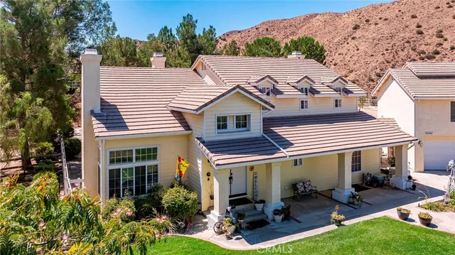 a front view of a house with swimming pool and furniture