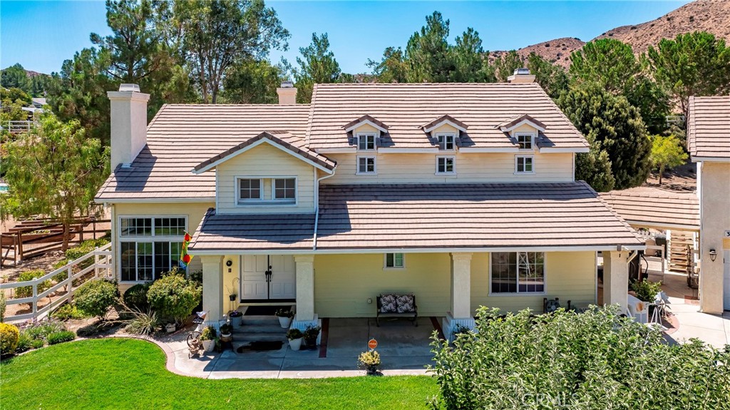 32201 Joaquin Road Acton, CA 93510 - Photo 6 of 75 a view of a white house with a yard potted plants and a large tree