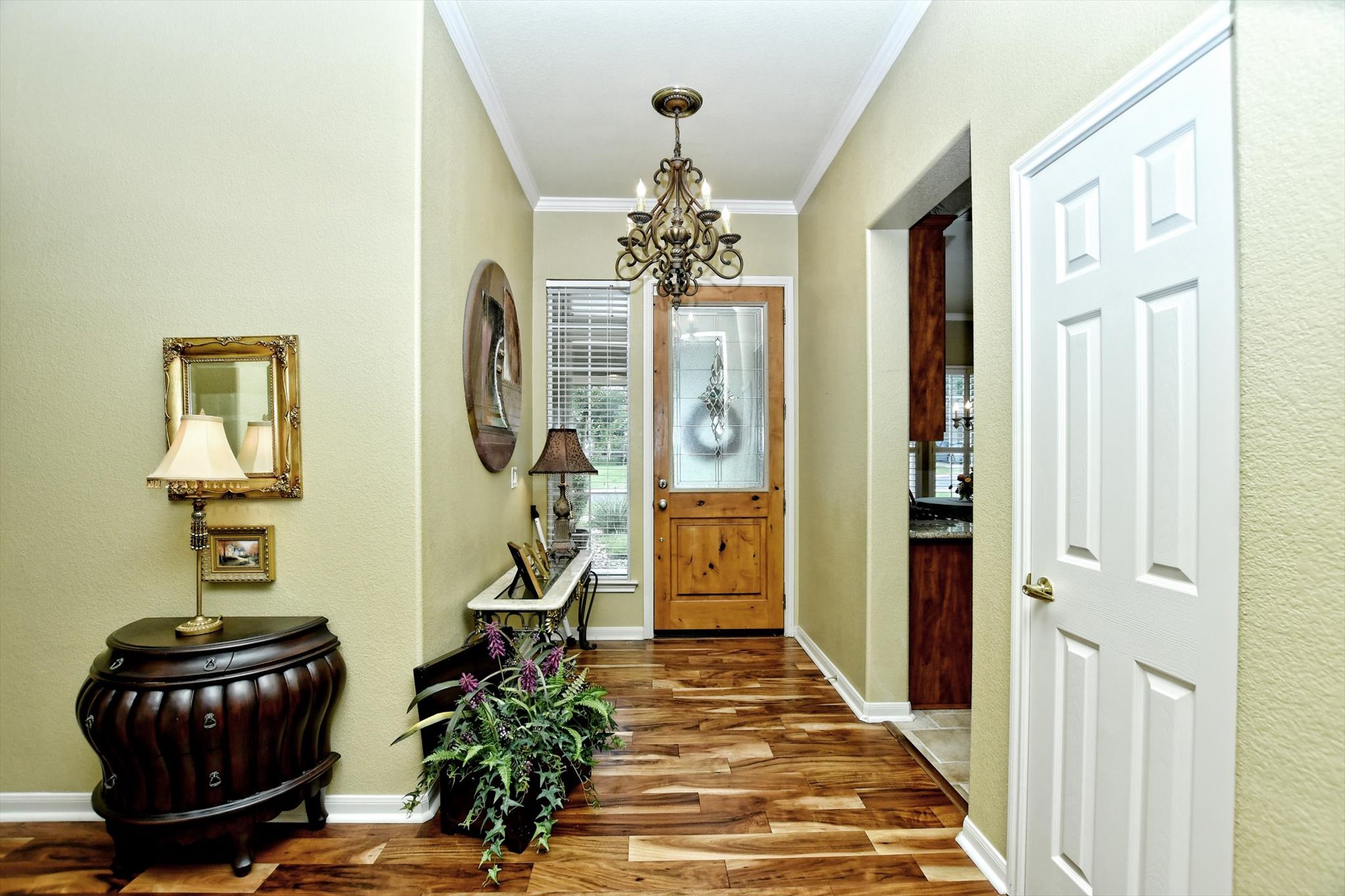 106 Nighthawk Way Georgetown, TX 78633 - Photo 4 of 29 A welcoming entryway boasts rich hardwood flooring and a stylish chandelier, setting a charming tone.