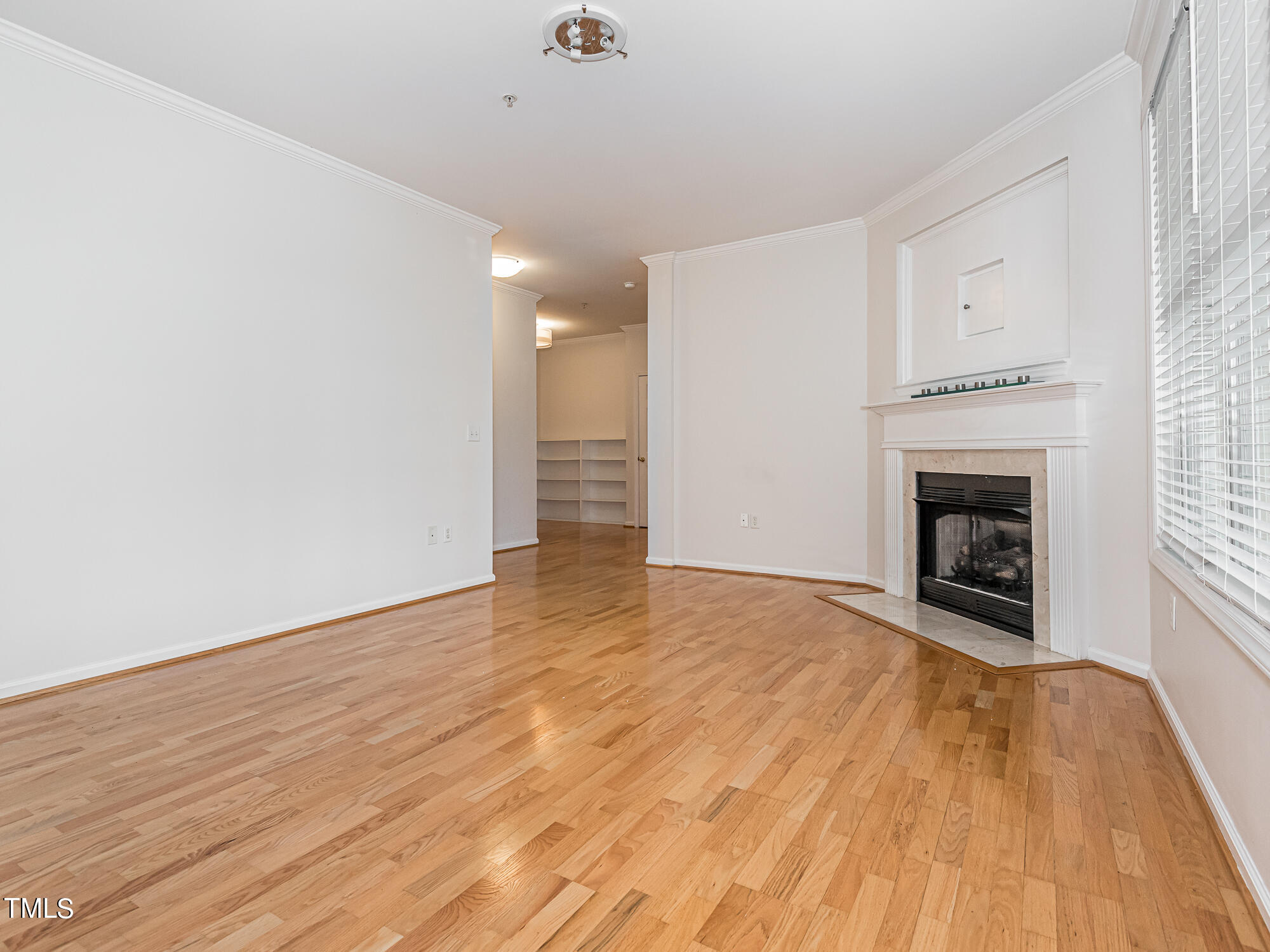 8041 Allyns Landing Way, Unit 103 Raleigh, NC 27615 - Photo 16 of 33 a view of empty room with wooden floor and fireplace