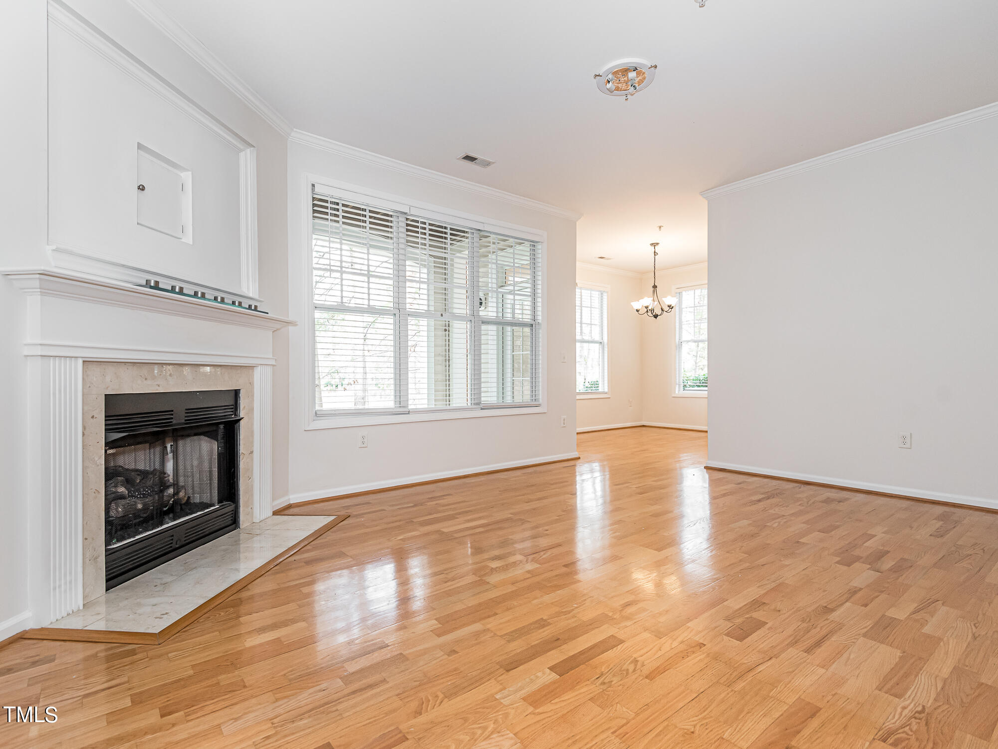 8041 Allyns Landing Way, Unit 103 Raleigh, NC 27615 - Photo 17 of 33 a view of an empty room with exposed radiator and fireplace
